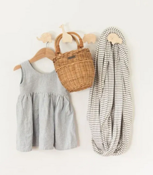 Gray dress, wicker basket, and striped blanket on a white background