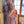 Woman wearing a duster robe with floral pattern holding a puppy indoors near a window