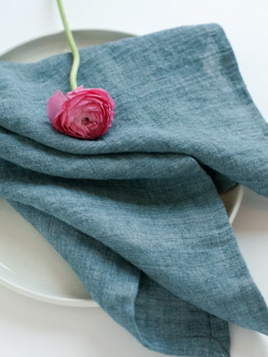 Blue napkin with a pink flower on a white plate