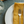 White plate with a yellow fabric napkin, fork, and knife on a textured surface.