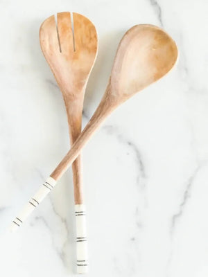 Two wooden utensils on a white marble surface