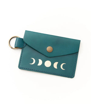 Teal leather cardholder with moon phase design on a white background