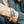 Close-up of a wrist wearing multiple bracelets with a blurred background