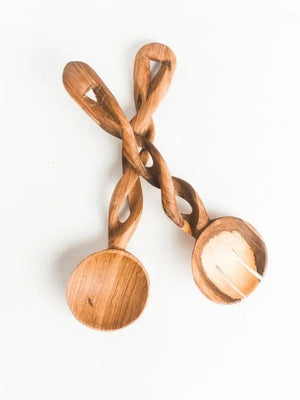 Twisted wooden spoon and fork on a white background