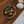 Round wooden tray with orange spherical objects and herbs on a wooden surface with a book.
