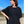 Person wearing a black boxy top on a beach with a clear blue sky.