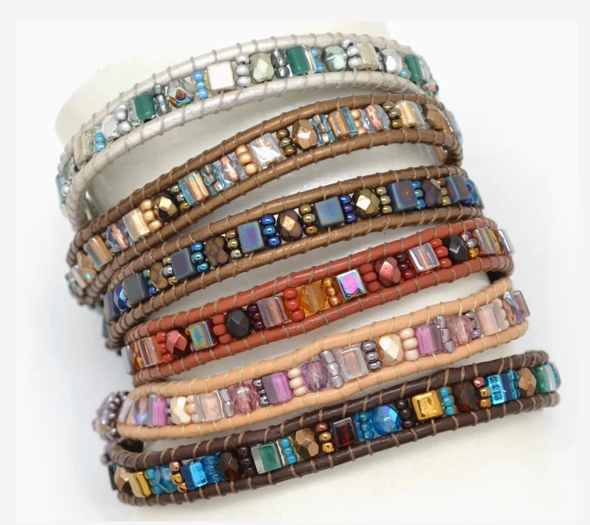 Stack of colorful beaded bracelets on a white background