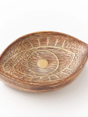Wooden dish with eye design on a white background