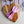 Heart-shaped wooden cutting board with a pink napkin on top on a patterned tablecloth.