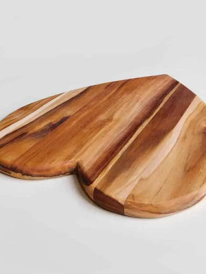 Wooden heart shaped cutting board on a light gray background
