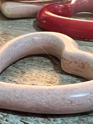 Decorative stone heart-shaped object on a wooden surface