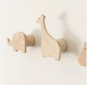 Wooden animal-shaped hooks on a white wall