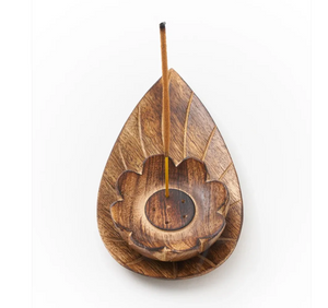 Handcarved wooden incense holder shaped like a leaf on a white background