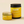 Two yellow jars with lids and labeled 'kandu' on a beige background