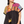 Woman wearing a colorful patterned top with a black base on a white background