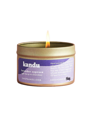 Kandu lavender eucalyptus candle in a tin with a lit wick on a white background
