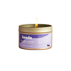 Kandu lavender eucalyptus candle in a tin with a lit wick on a white background