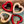 Two red and two beige heart-shaped ceramic items on a wooden surface