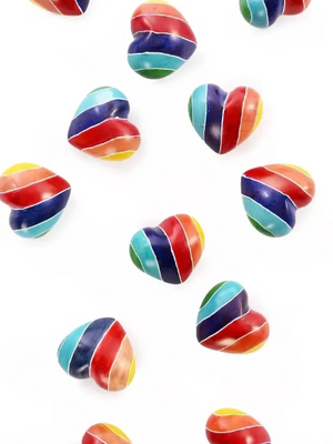 Rainbow-striped, heart-shaped figurines on a white background