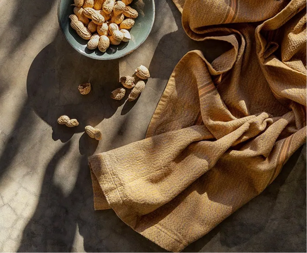 Peanuts on a stone surface with a folded yellow cloth