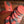 Set of orange coasters and holder with a decorative pattern on a woven surface
