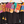 Two colorful dresses with black skirts on hangers against a white background
