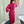 Woman in a pink floral robe standing in a bathroom with tiled walls and a bathtub.
