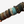 Multiple beaded bracelets on a wooden stick against a white background
