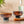 Two brown glasses on a wooden surface with a bottle and lime in the background.