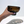 Hand holding a dark brown glass against a white background