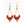 Pair of beaded earrings with orange, brown, and gold colors on a white background